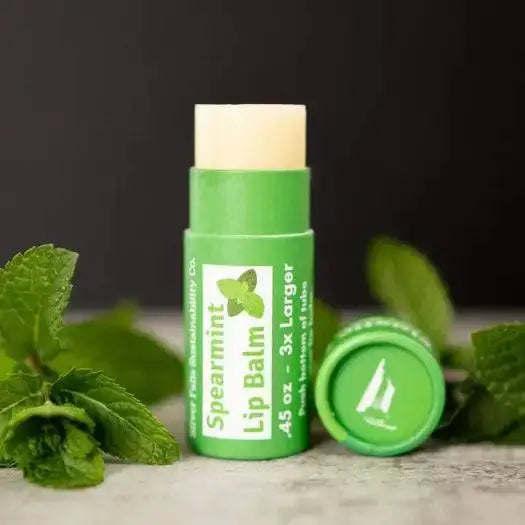 Spearmint Natural Lip Balm in green container with mint leaves, promoting organic moisture and nourishment for lips.