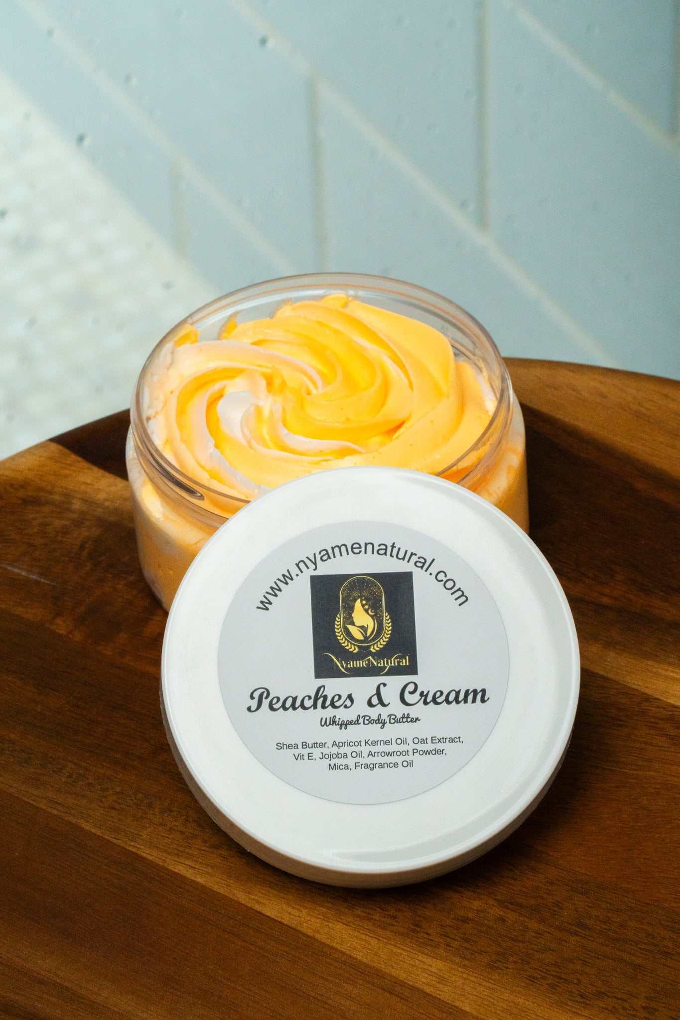 Peaches & Cream Body Butter in a jar, featuring a creamy swirl design and labeled with product details.