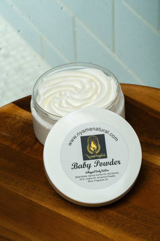 Silky Baby Powder Body Butter in a jar on wooden surface, offering moisture without sticky residue.