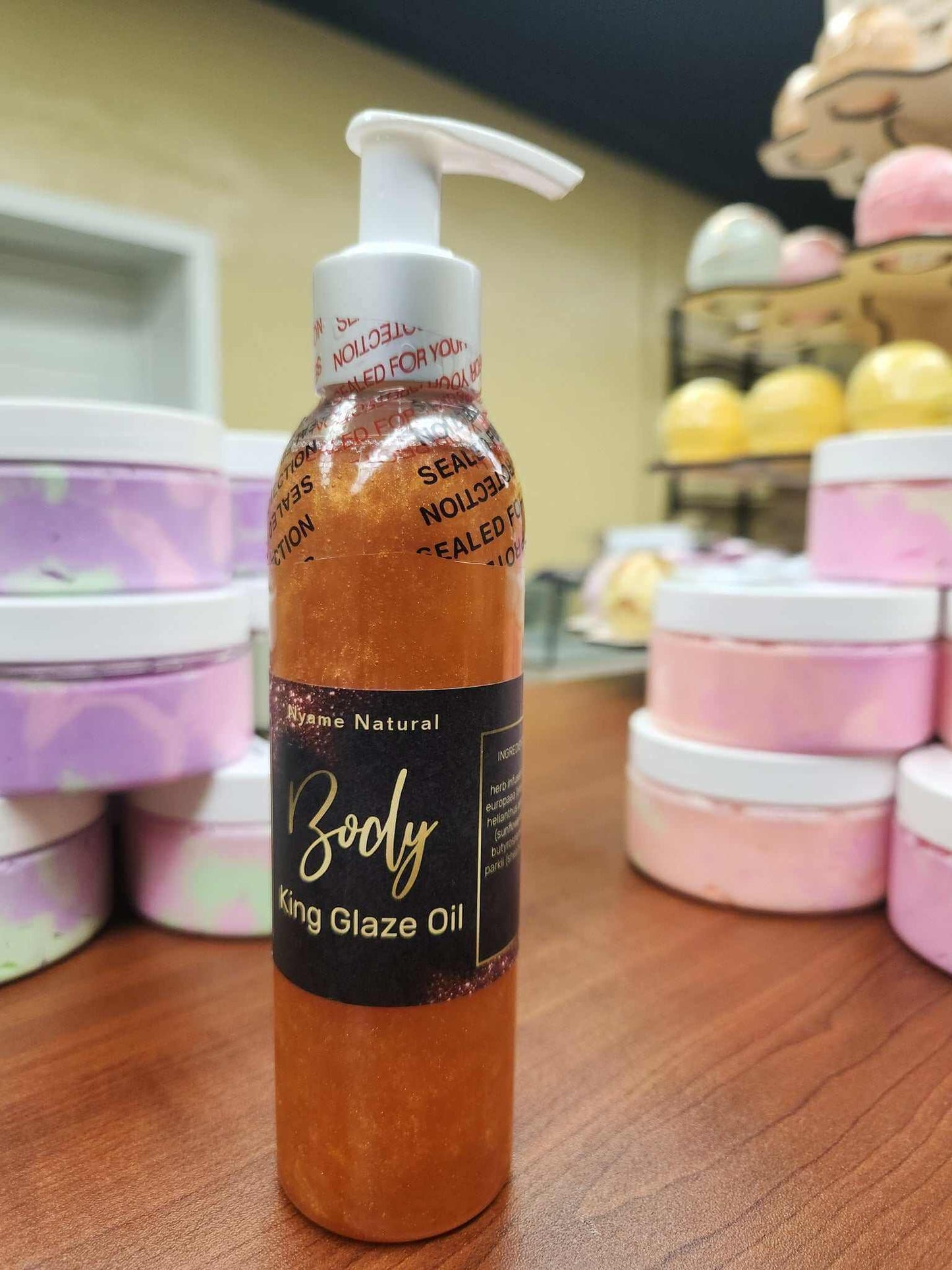 King Glaze Pheromone Oil bottle showcasing a luxurious golden sheen and herbal infusion on a wooden surface.