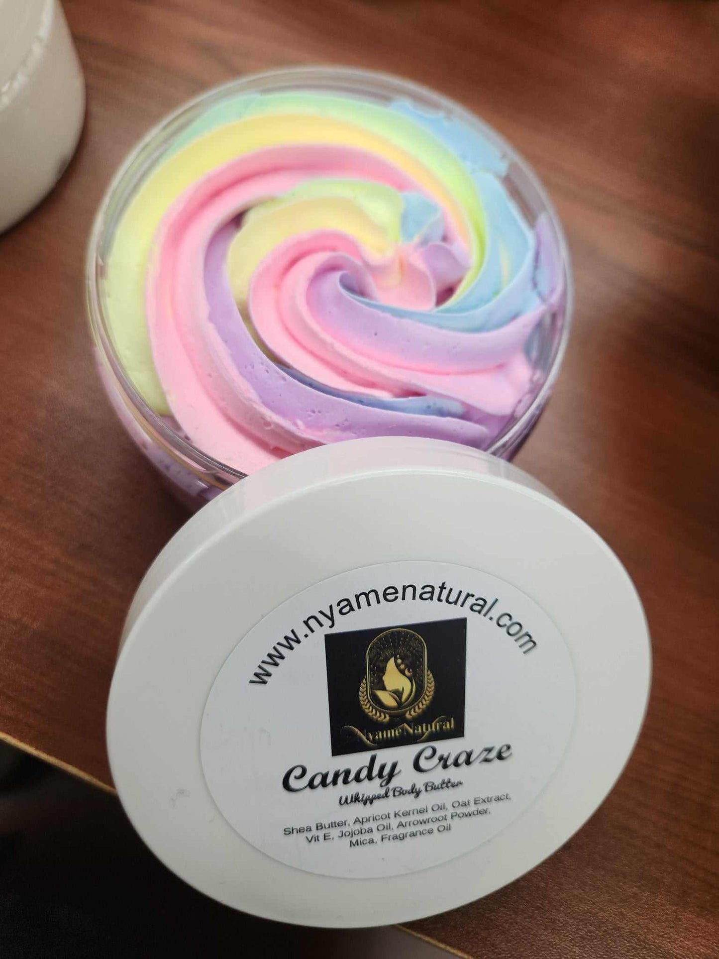 Colorful Candy Craze Body Butter in a jar with swirls of pastel pink, yellow, and blue, promoting luxurious hydration.