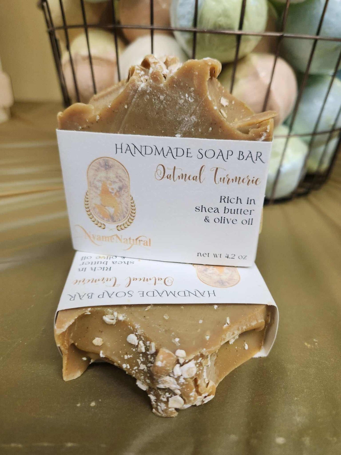 Turmeric & Oat Meal soap bar with shea butter and olive oil, displayed on a soft surface.