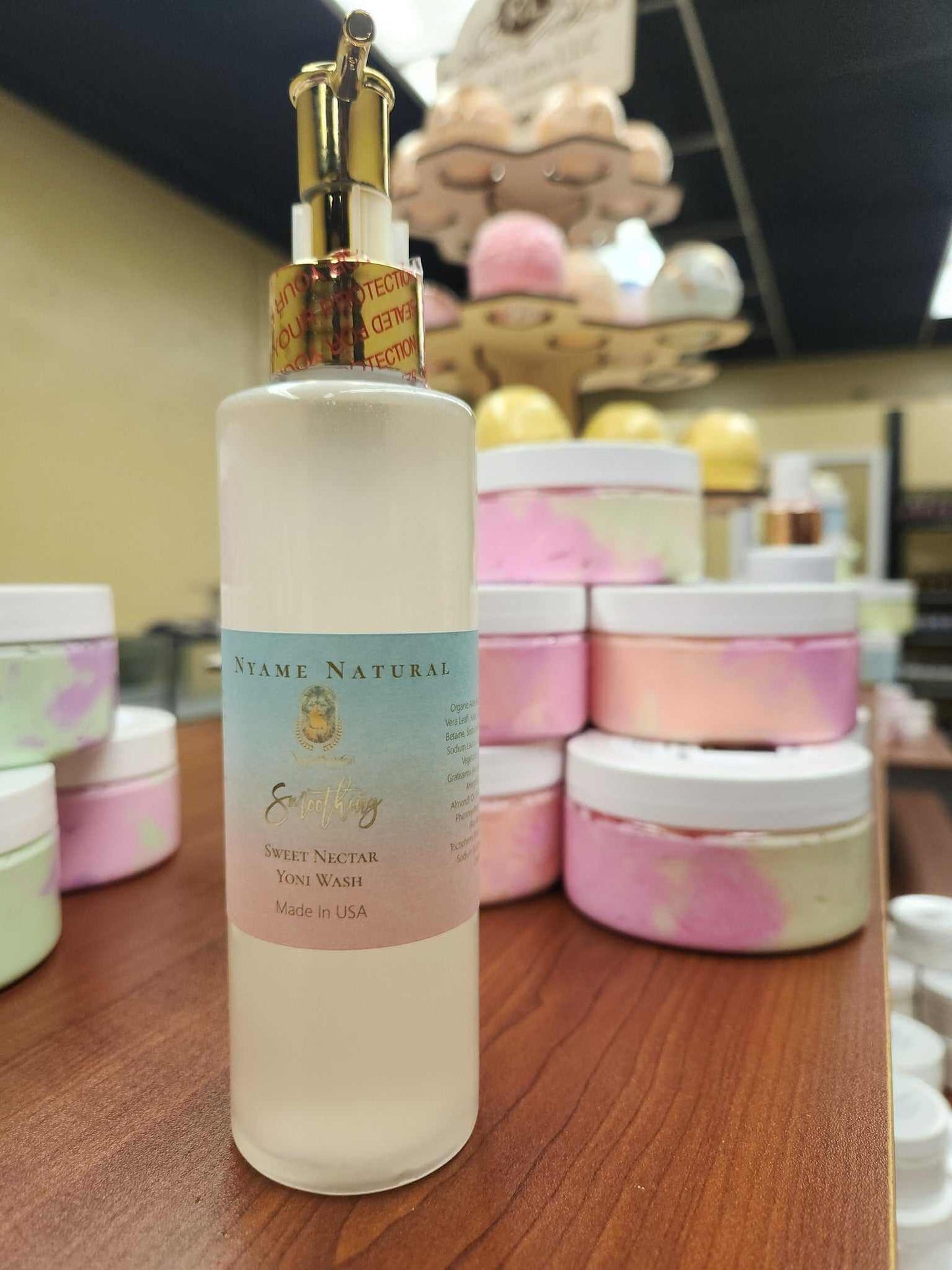 Sweet Yonie Wash bottle with moisturizing formula for freshness, surrounded by pastel jars in a store setting.