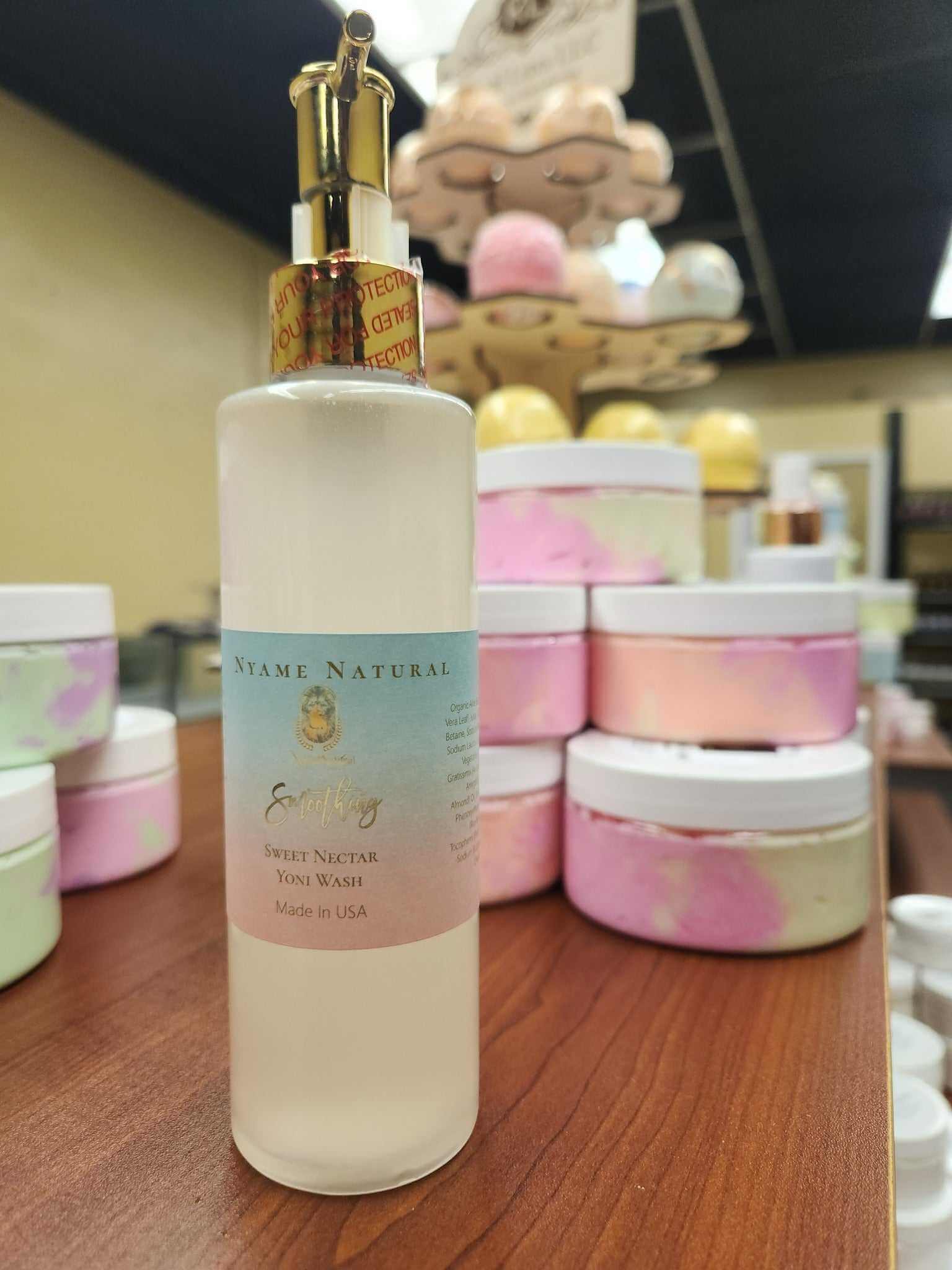 Sweet Yonie Wash bottle with moisturizing formula for freshness, surrounded by pastel jars in a store setting.