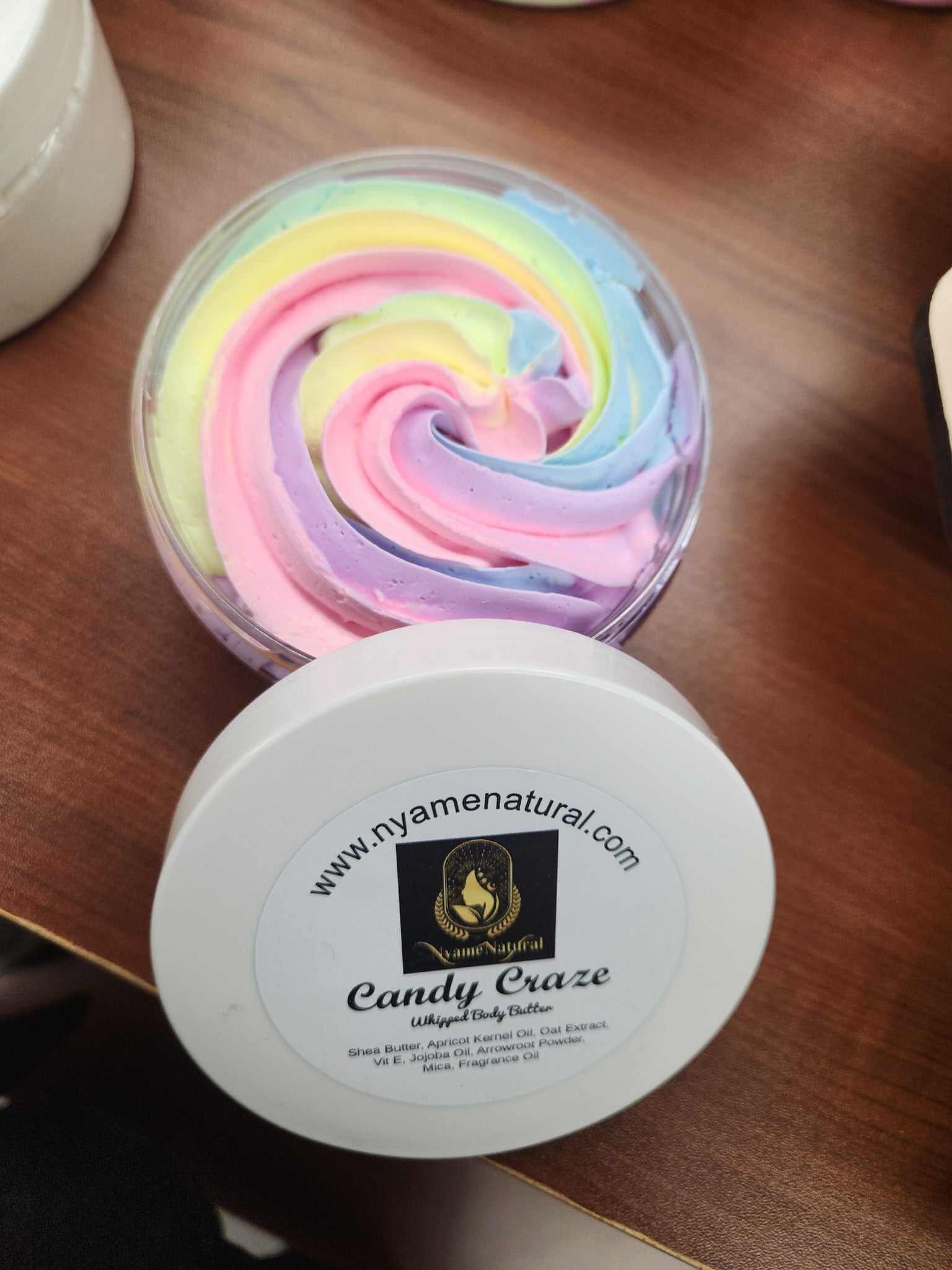 Colorful Candy Craze Body Butter in a container, showcasing swirls of vibrant pastel colors for luxurious skin hydration.