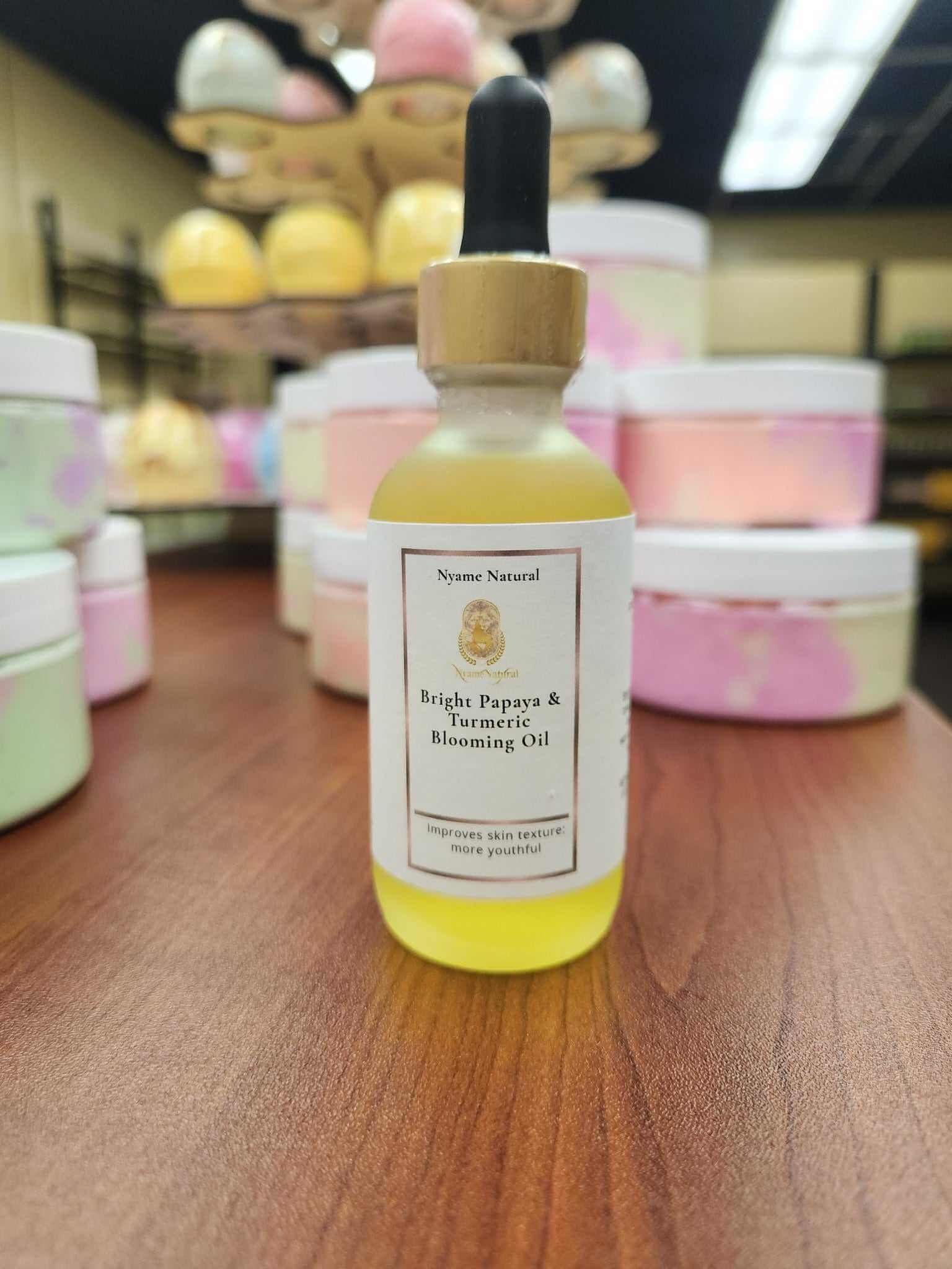 Bright Papaya & Turmeric Blooming Oil in dropper bottle, showcasing nourishing skincare benefits against colorful jars.