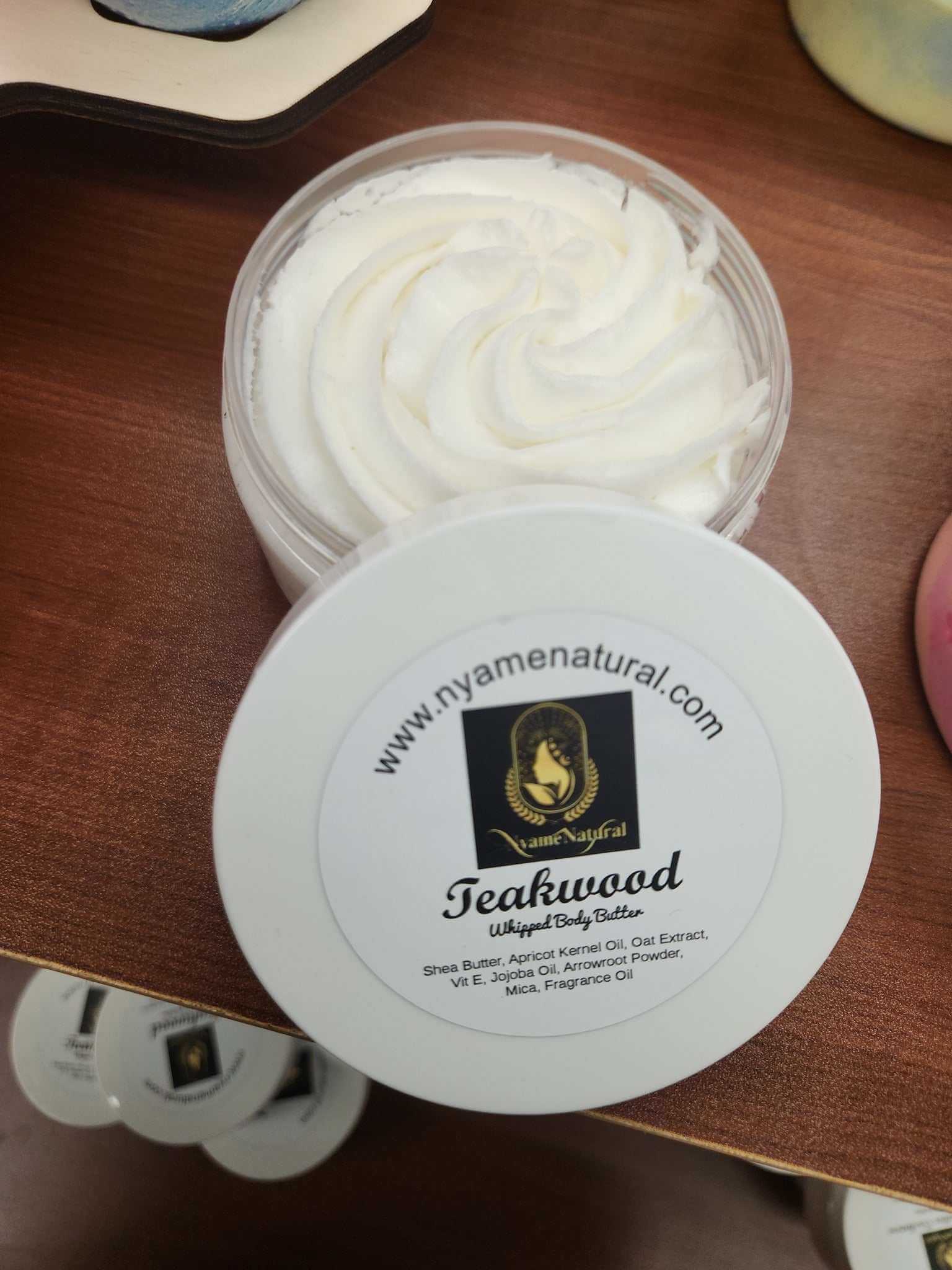Teakwood Body Butter in a clear container, showcasing creamy, whipped texture for luxurious skin nourishment.