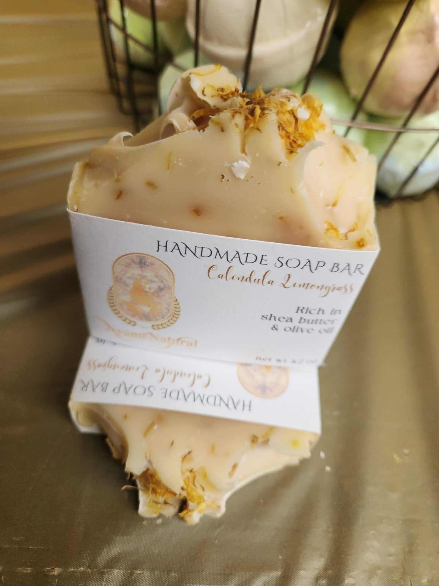 Handmade Calendula Lemongrass Bar Soap with olive oil and shea butter, displayed on a golden surface.