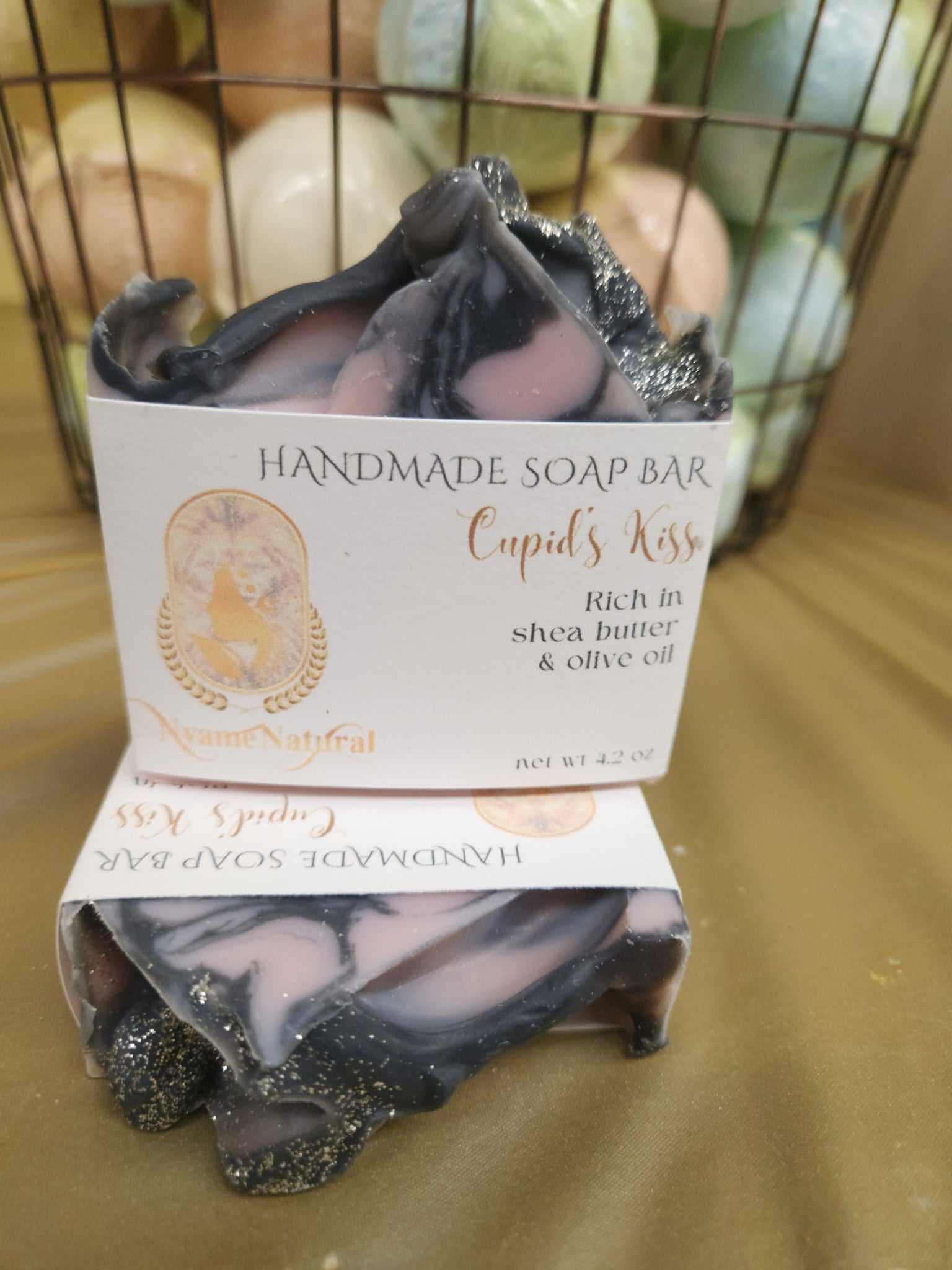 Handmade Cupid Kiss Soap Bar rich in shea butter and olive oil, displaying a swirl of pink and black colors.