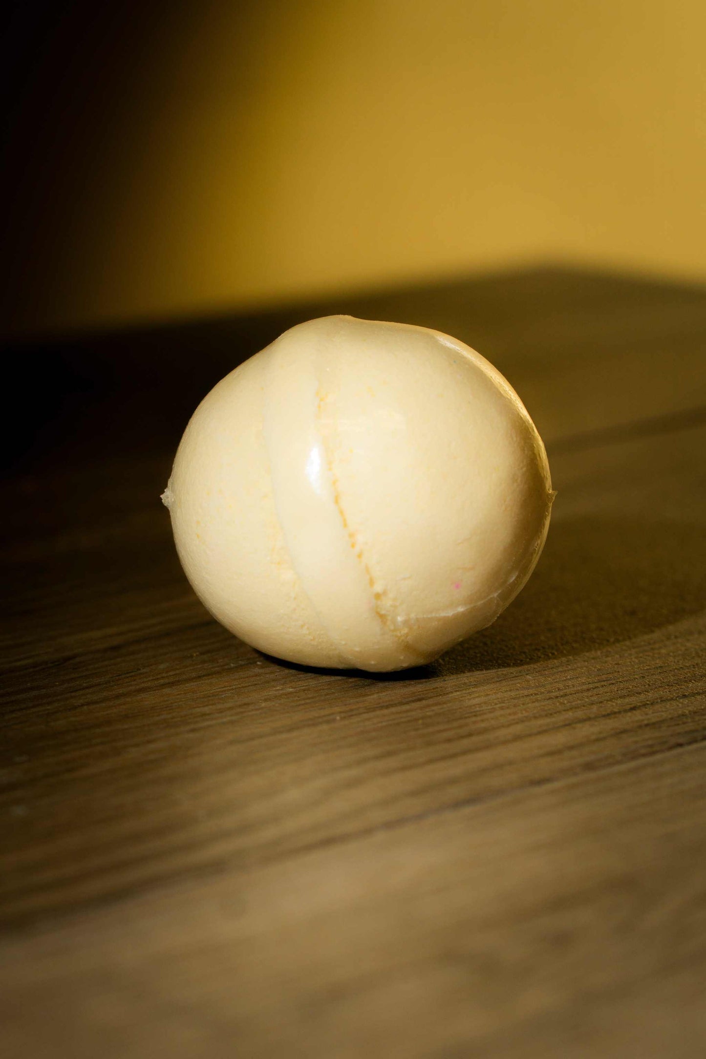 Luxurious Body Bath Bomb on wooden surface, handcrafted with soothing skin-loving ingredients.