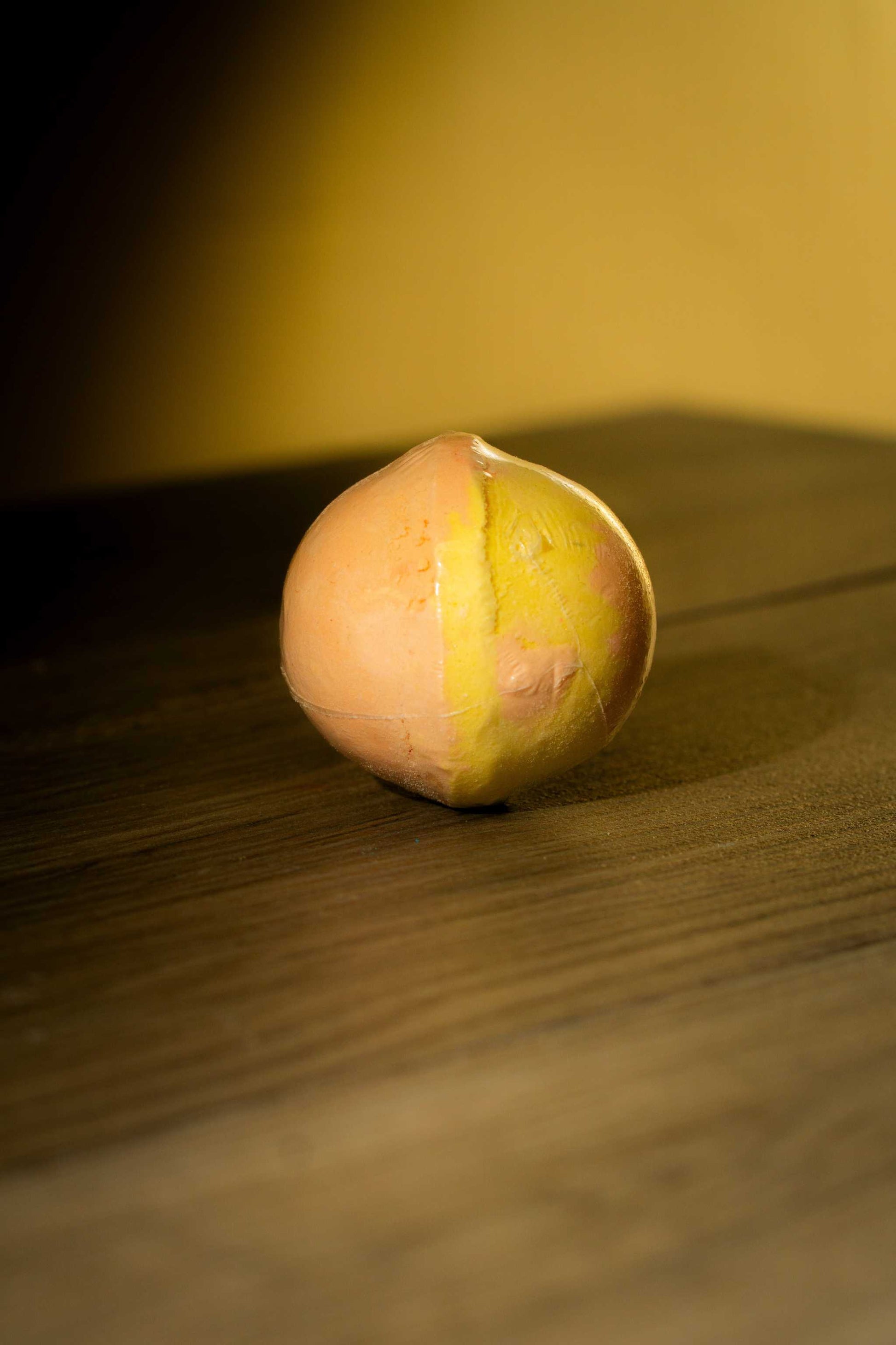 Luxurious Body Bath Bomb on wooden surface, showcasing unique colors for a soothing bath experience.