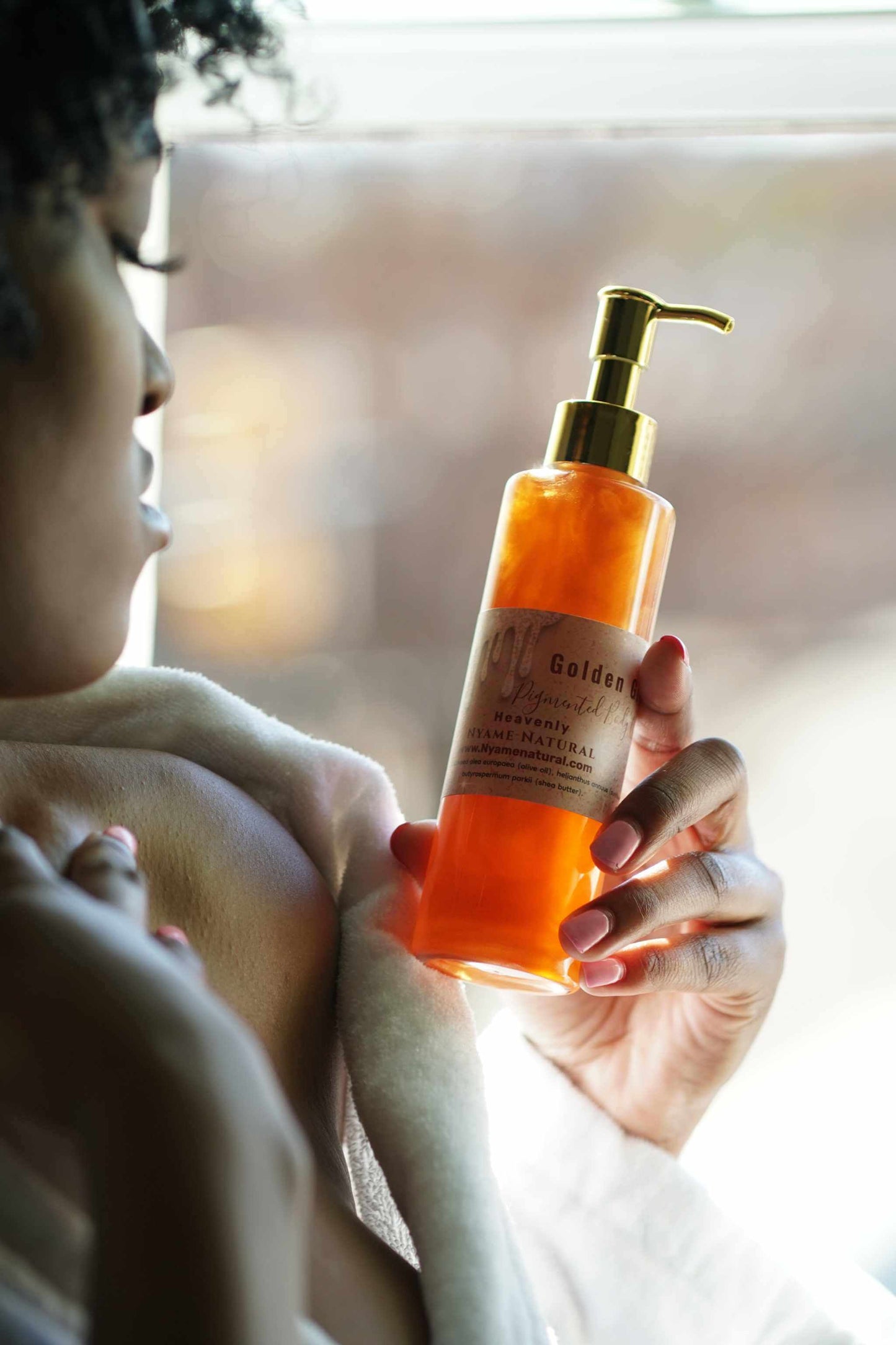 Copper Pigmented Pheromone Body Oil in a woman's hand, showcasing its luxurious glow and herbal scent.