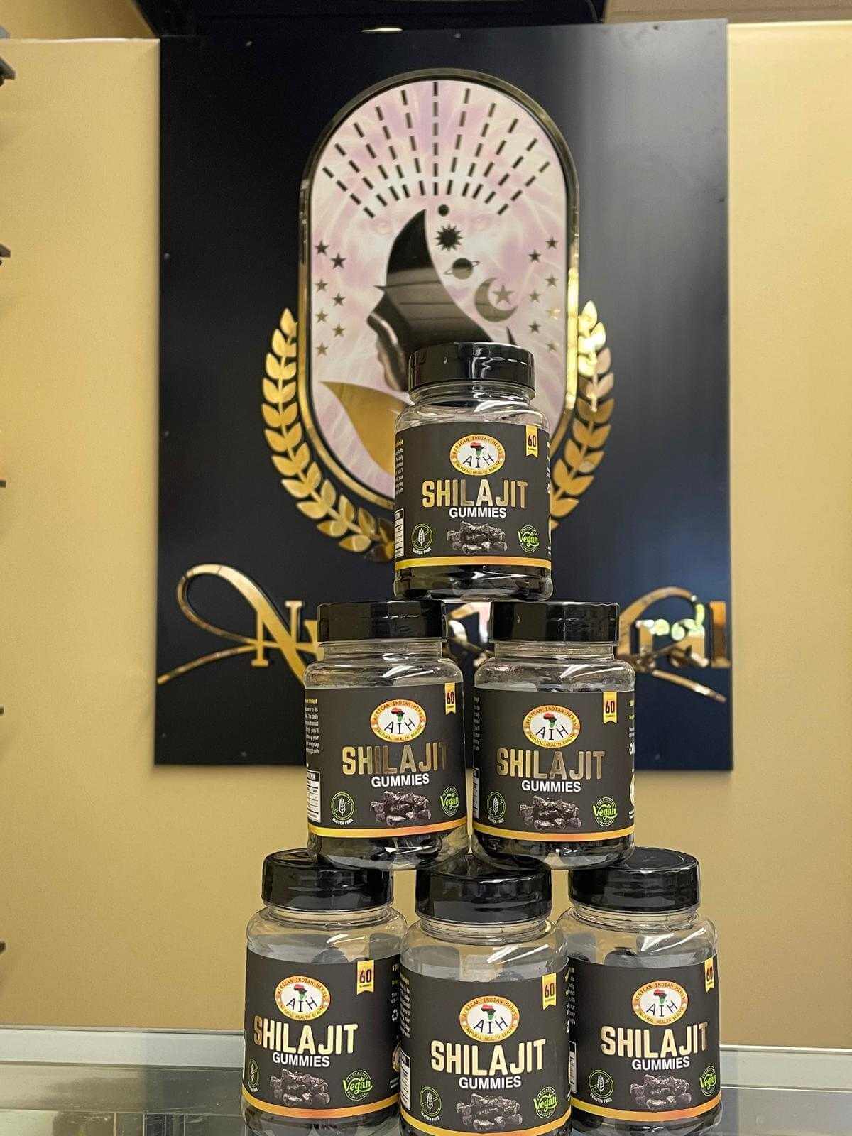 Stack of AIH Shilajit Gummies jars showcased in a display.