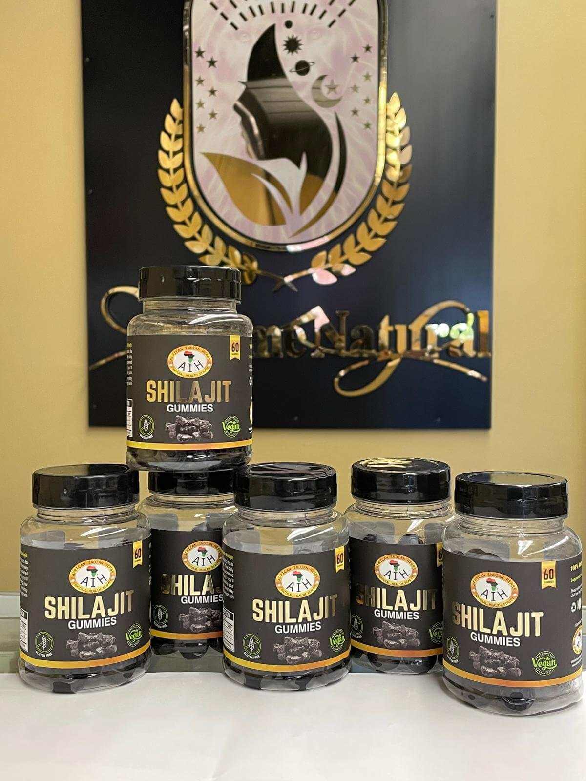 Bottles of AIH Shilajit Gummies displayed against a branded backdrop, promoting health and wellness.
