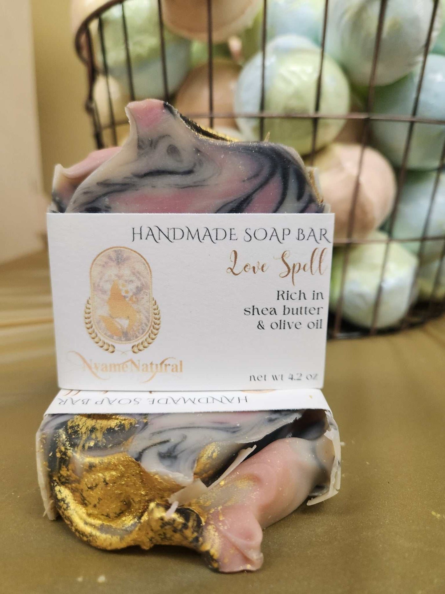 Handmade Love Spell Bar Soap enriched with shea butter and olive oil, showcasing swirls of pink and gold.