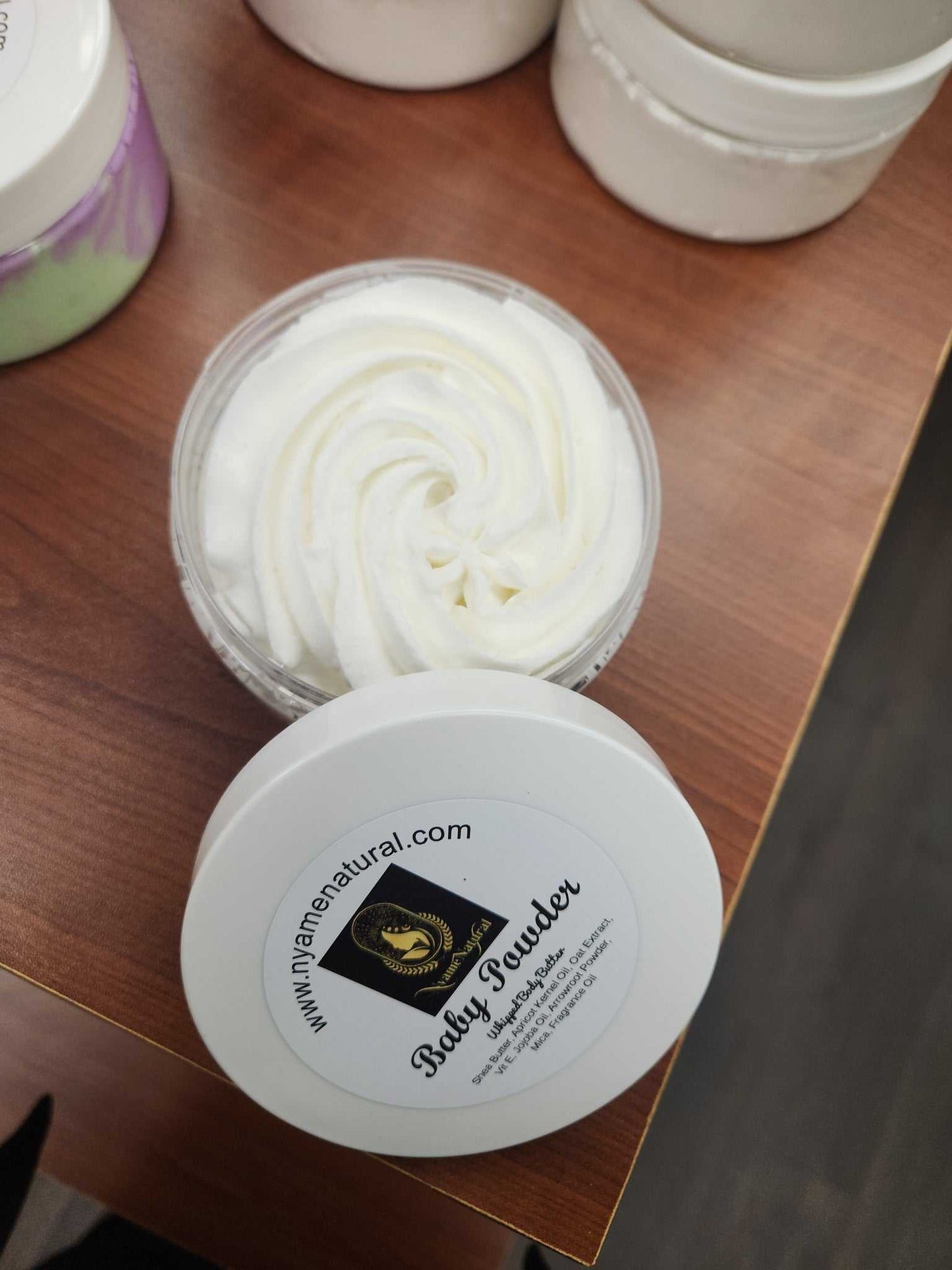 Container of Baby Powder Body Butter with silky texture, perfect for nourishing skin.