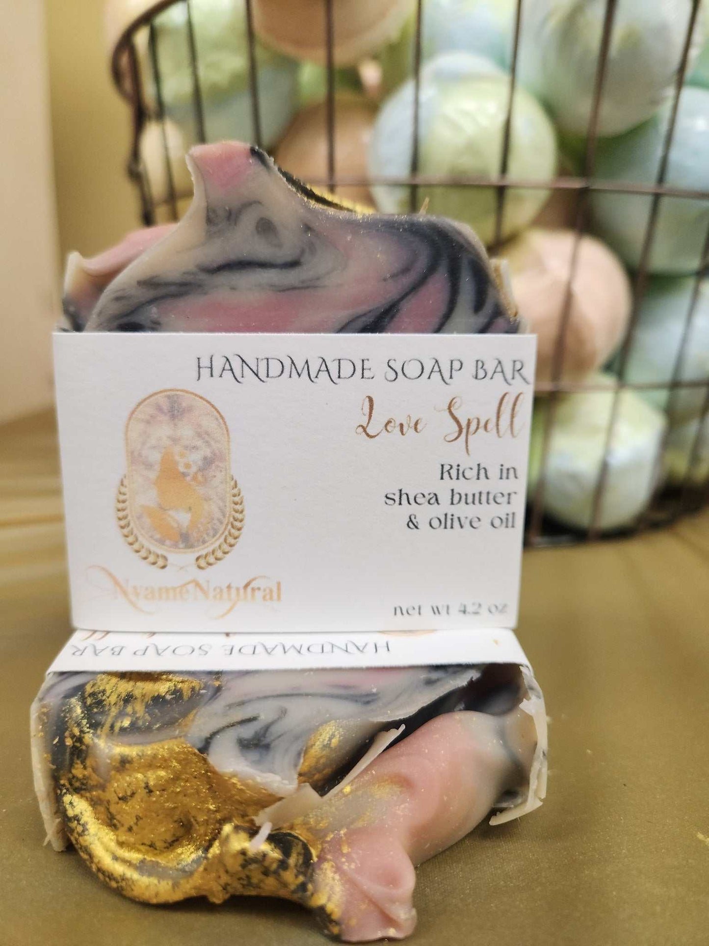 Handmade Love Spell Bar Soap featuring shea butter and olive oil, uniquely swirled with pink and gold accents.