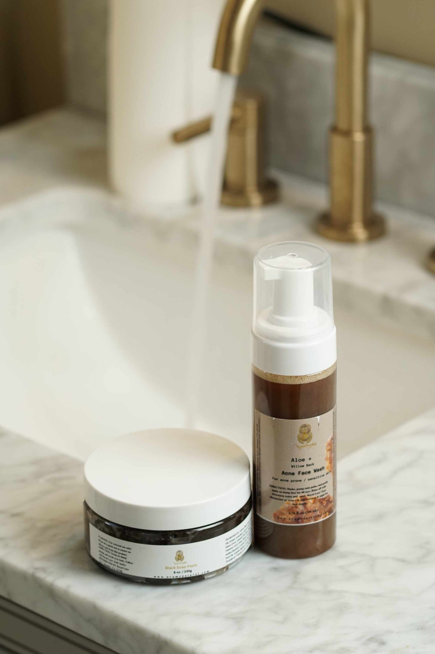 Natural Face Acne Wash and Black African Paste on a marble counter, ideal for sensitive and oily skin.