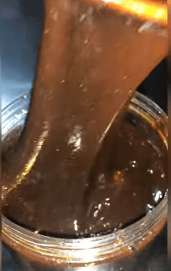 Lusciousness Drip Honey (Kayanmata) Goron Tula pouring from a jar, highlighting its rich, dark texture.